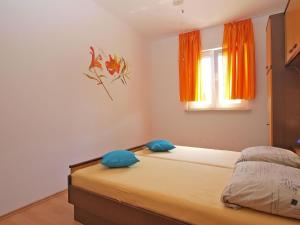 two beds in a room with orange curtains at Ferienwohnung für 3 Personen ca 36 qm in Pula-Fondole, Istrien Istrische Riviera in Pula