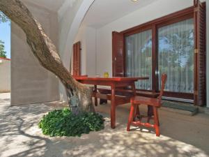 una mesa y una silla junto a un árbol en Ferienwohnung für 4 Personen ca 42 qm in Fažana, Istrien Istrische Riviera - b62492, en Fažana