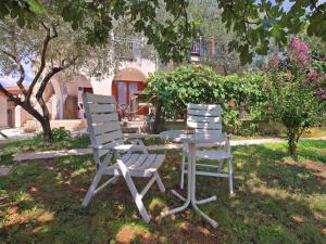 dos sillas y una mesa bajo un árbol en Ferienwohnung für 4 Personen ca 42 qm in Fažana, Istrien Istrische Riviera - b62492, en Fažana