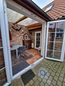 eine offene Terrasse mit einem Tisch und einer Glastür in der Unterkunft Hexenhaus in Lüneburg