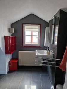 een badkamer met een wastafel en een raam bij Hexenhaus in Lüneburg