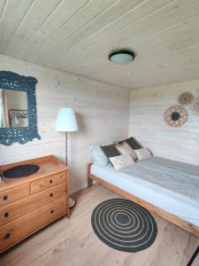 Dormitorio pequeño con cama y espejo en Domek nad Dadajem, en Kromerowo