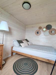 1 dormitorio con 1 cama en una habitación de madera en Domek nad Dadajem, en Kromerowo