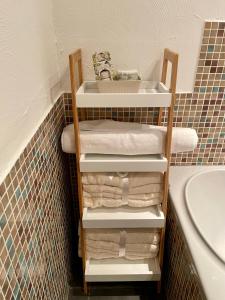 a bathroom with a sink and a shelf with towels at Apartment by the park, for bike lovers in Alsfeld