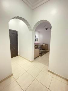 a hallway with white walls and a door and a living room at نايتس للوحدات المفروشة in Tabuk