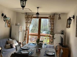 a living room with a table and a large window at Kurnik Polski agroturystyka in Tykocin