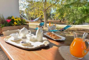 un tavolo con colazione a base di tè e succo d'arancia di Trullo Alcova in der Nähe des Meeres a San Vito dei Normanni