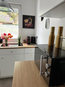 a kitchen with white cabinets and a black counter top at Deluxe Apartement mit Terrasse in Duisburg