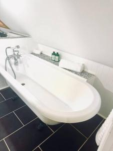 a white bath tub in a white bathroom at Gleddoch Coach House in Langbank