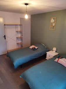 a bedroom with two beds and a book shelf at Location saisonnière Cravant Deux Rivières 89460 in Cravant