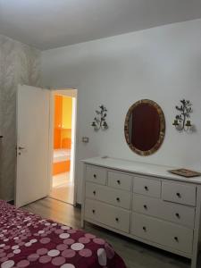 una camera da letto con cassettiera e specchio sul muro di casa vacanze isabel a Mascali
