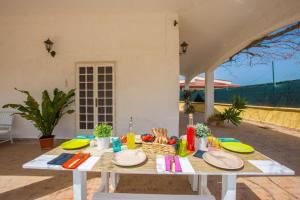 een witte tafel met borden op een patio bij Villa Mediterranea in San Vito dei Normanni