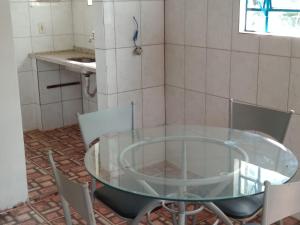 uma mesa de vidro e cadeiras num quarto em Joanopolis Inn - Mantiqueira 1 em Joanópolis