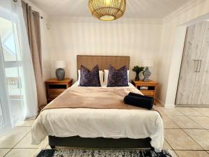 a bedroom with a large bed with purple pillows at This Is Not The Post Office in Riebeek-Kasteel