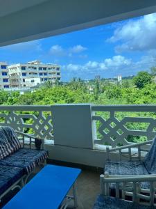 einen Balkon mit 2 Stühlen und einem blauen Tisch in der Unterkunft Ocean Blue Retreat-3 minute walk to Nyali Center and 3 minute walk to the Beach in Mombasa