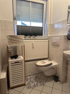 a bathroom with a toilet and a sink and a window at ELMIRA in Memmingen