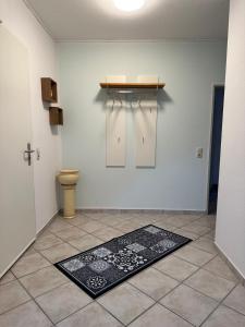 een badkamer met een toilet en een tapijt op de vloer bij ELMIRA in Memmingen