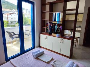 a room with a bed with a book shelf and a window at Glory Suites in Budva