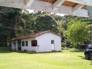uma pequena casa branca no meio de um quintal em Joanopolis Inn - Mantiqueira 1 em Joanópolis