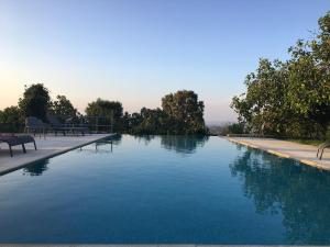 una piscina con acqua blu, sedie e alberi di Quinta d'Abegoa a Marvão