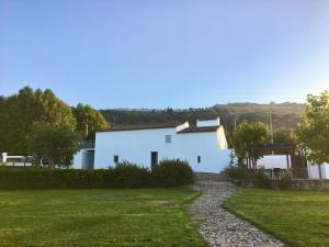 une maison blanche avec un chemin en gravier devant elle dans l'établissement Quinta d'Abegoa, à Marvão