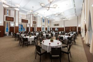 un salón de banquetes con mesas y sillas blancas en The Charles F. Knight Center, en University City