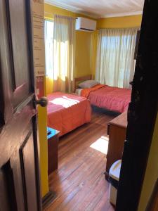 una habitación de hotel con 2 camas y una puerta abierta en Hostal Radal Molina, en Molina