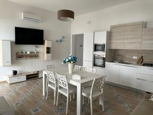 a kitchen with a dining room table and chairs at La dolce casa di Sara e Alessia in San Pietro in Bevagna
