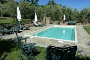 - une piscine avec des chaises et des parasols dans la cour dans l'établissement Ferienhaus für 6 Personen ca 125 qm in Colle di Buggiano, Toskana Provinz Pistoia, à Massa e Cozzile