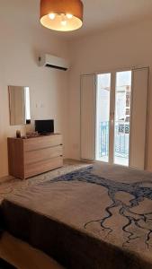 een slaapkamer met een bed en een dressoir met een raam bij Il terrazzo sul porto in Sciacca