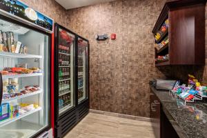 a grocery store aisle with a refrigerator and shelves at Cobblestone Hotel & Suites - Rhinelander in Rhinelander