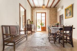 une salle à manger avec des bancs en bois et une table dans l'établissement Ferienhaus in Santa Margalida mit Kleinem Pool, à Santa Margalida