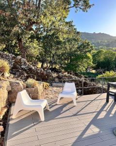two white chairs sitting on top of a wooden deck at Quinta d'Abegoa in Marvão