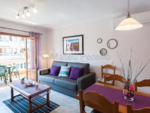 ein Wohnzimmer mit Sofa und Tisch in der Unterkunft Charmante Wohnung in Son Baulo mit Grill in Can Picafort