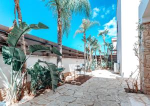 un patio con palmeras y un edificio en WealthyStays: Sunset Villa en Paralimni