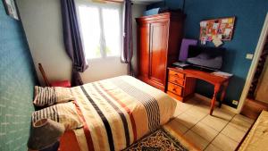 una camera da letto con un letto, una scrivania e una finestra di Maison de famille a Benet