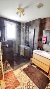 un bagno con doccia, lavandino e vasca di Maison de famille a Benet