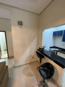 a kitchen with a black counter and a chair in a room at Casa Sales - Alter do Chão in Santarém