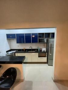 a kitchen with blue cabinets and a stainless steel refrigerator at Casa Sales - Alter do Chão in Santarém