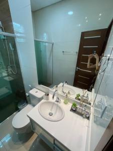 W łazience znajduje się umywalka, toaleta i lustro. w obiekcie Casa Sales - Alter do Chão w mieście Santarém