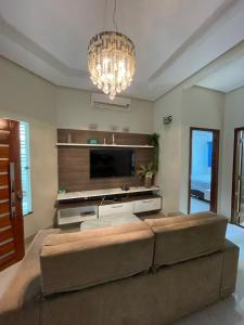 a living room with a couch and a flat screen tv at Casa Sales - Alter do Chão in Santarém