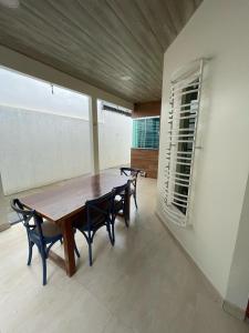 Casa Sales - Alter do Chão في سانتاريم: غرفة طعام مع طاولة وكراسي خشبية