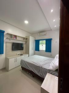 a bedroom with a bed and a flat screen tv at Casa Sales - Alter do Chão in Santarém