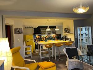 een keuken met een geel eiland in een kamer bij Ferienwohnung in Bad Sachsa mit Grill, Terrasse und Garten in Bad Sachsa