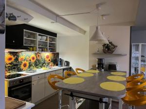 een keuken met een tafel en enkele gele stoelen bij Ferienwohnung in Bad Sachsa mit Grill, Terrasse und Garten in Bad Sachsa