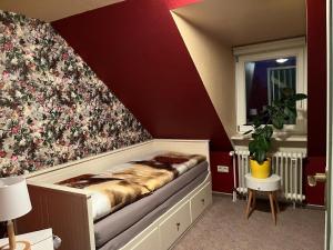 een slaapkamer met een bed met een bloemrijke muur bij Ferienwohnung in Bad Sachsa mit Grill, Terrasse und Garten in Bad Sachsa