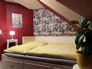 een slaapkamer met een bed met een bloemenmuur bij Ferienwohnung in Bad Sachsa mit Grill, Terrasse und Garten in Bad Sachsa