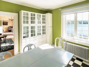 a dining room with a table and a large window at Holiday home FREDRIKSBERG III in Fredriksberg