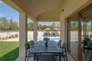 a patio with a table and chairs and a pool at Ferienhaus Evida in Poreč