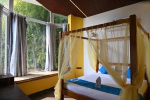 a bedroom with a canopy bed and a window at Olive in Tāla